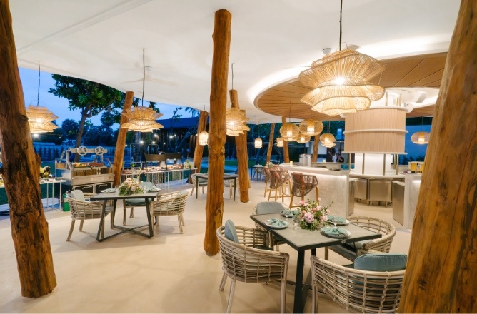http://Modern%20outdoor%20dining%20area%20with%20wooden%20columns,%20wicker%20chairs,%20and%20round%20tables%20decorated%20with%20flowers.%20Warm%20lighting%20creates%20a%20cozy,%20inviting%20atmosphere.