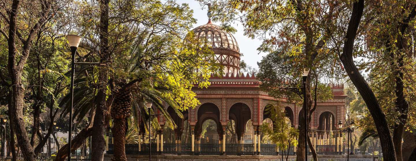 A building nestled among trees, located in the center of a lush park.