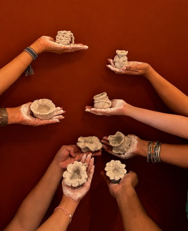 A diverse group of individuals proudly holding clay pots, showcasing their craftsmanship and community spirit.